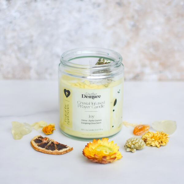 a coconut soy wax prayer candle with citrine crystal to promote joy